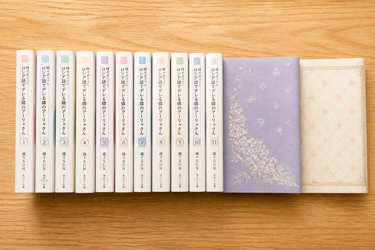木目の机の上にきれいに整列して並べられた複数冊の文庫本とブックカバー