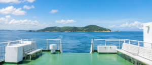 青空と海を背景にした島へ向かうフェリーの甲板