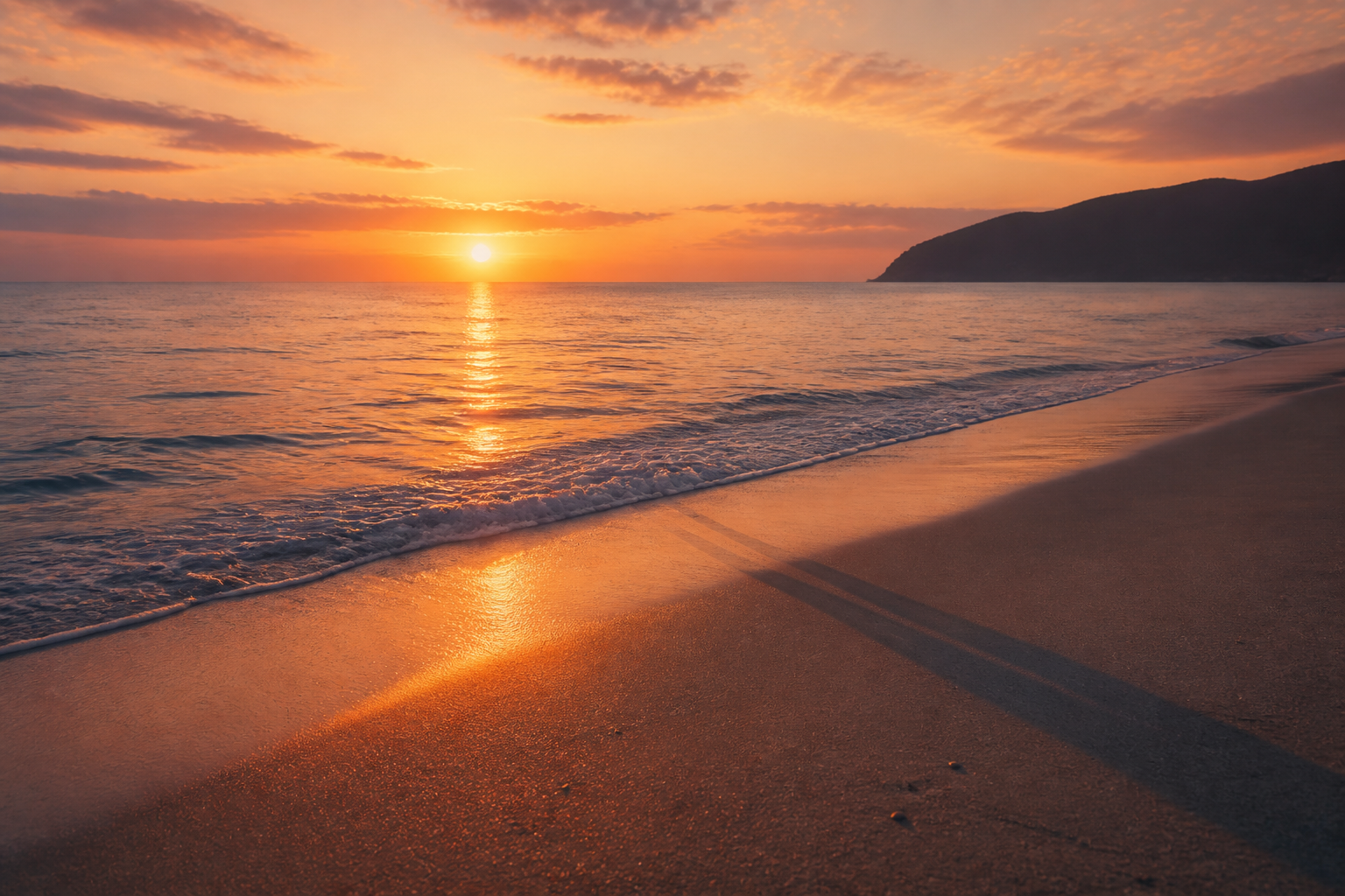夕暮れ時の静かな海と、波打ち際に立つ人物の影が長く伸びている様子